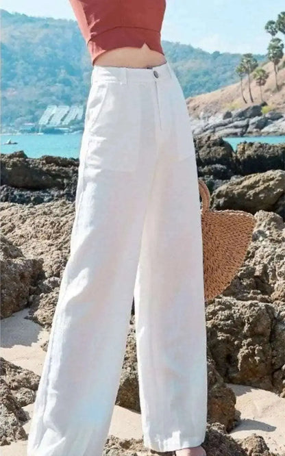 Photo d'un pantalon en coton et lin blanc porté par une femme, coupe droite et légère, disponible en blanc, noir et abricot.